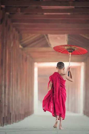 A Buddhist boy with red parasol
