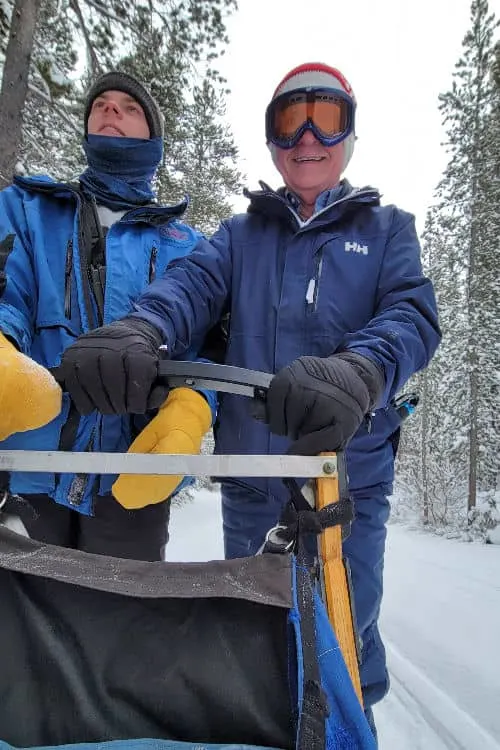 Riding on the back of the dog sled