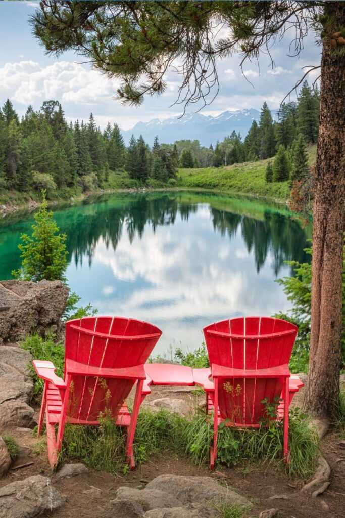 Red Adirondack chairs at the third lake of the Valley of the Five Lakes