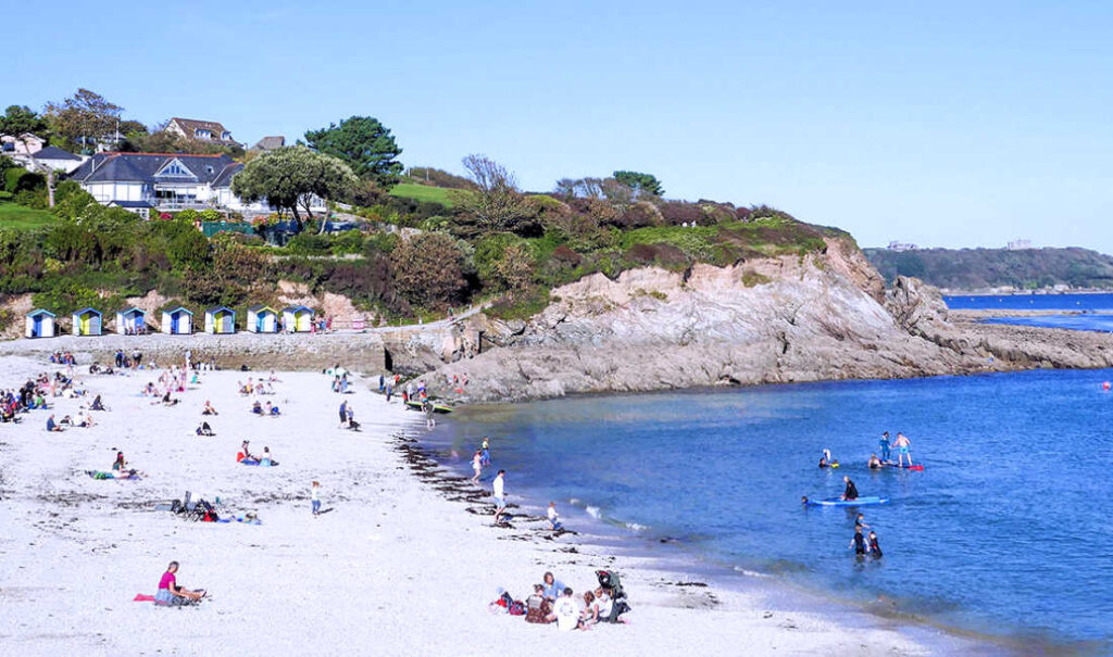 Beach-goers enjoying a sunny day at the seaside in Falmouth Beach