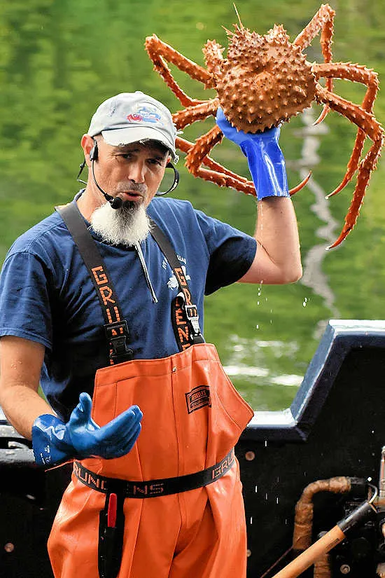 A crew member holds up a 6-year-old Alaskan king crab