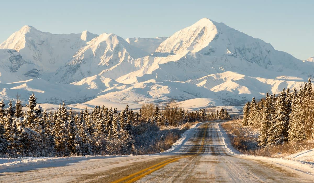 An Alaska highway and snow-capped mountains in winter