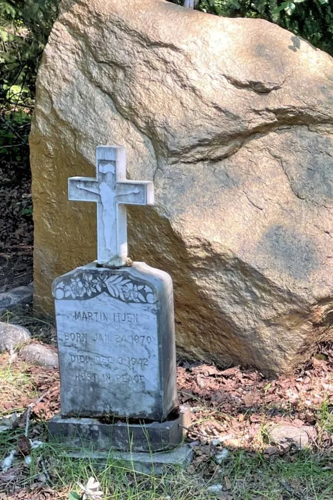 Martin Itjen's tombstone next to a giant nugget in Gold Rush Cemetery